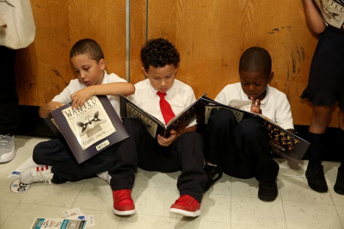 Kids receiving books as part of Pizza Hut: The Literacy Project