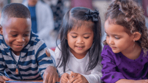 Three children reading a book.