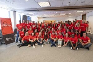 A group of people in red shirts posing for a photo.